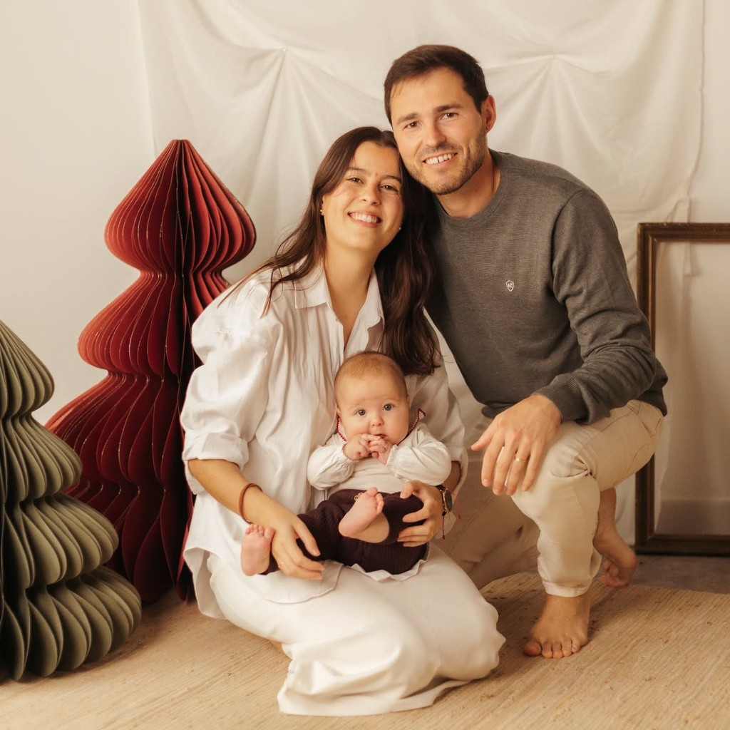 Family portrait of a couple with their baby in a soft studio setting
