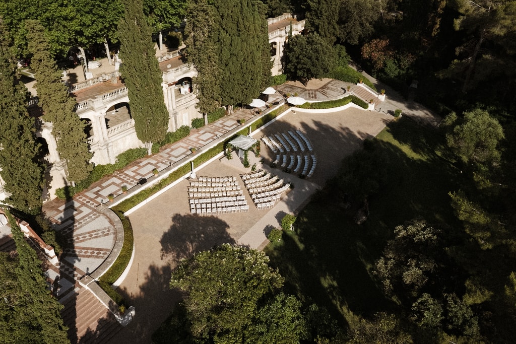 Aerial view of a formal garden with cypress hedges and a circular stone amphitheatre, wedding photography in Catalonia